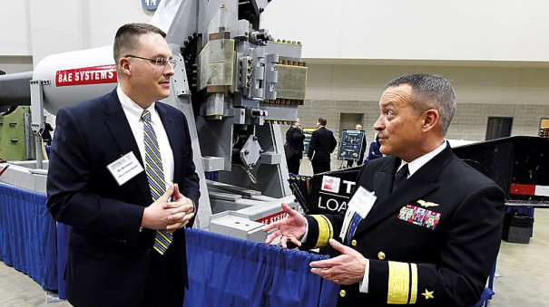 Ведущий инженер Центра надводной войны ВМС США Бен Макглассон (слева) на выставке S&T EXPO обсуждает с контр-адмиралом Мэтом Винтером плюсы и минусы рельсотронов (на заднем плане ствол ЭМП корпорации BAE Systems).