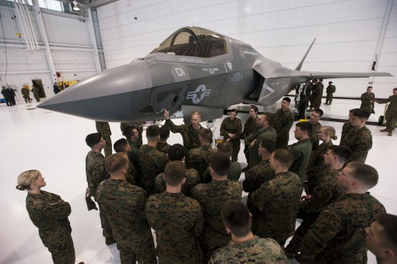 Major Mike Rountree, (C) a marine fighter attack training officer, shows naval flight students a U.S. Marine F-35B Joint Strike Fighter Jet during a roll-out ceremony at Eglin Air Force Base in Florida, February 24, 2012. The B model of the new single-engine, supersonic fighter jet can take off from shorter runways and can hover and land like a helicopter, according to a military statement. Picture taken February 24, 2012. REUTERS/Michael Spooneybarger (UNITED STATES - Tags: MILITARY) - RTR2YFY4