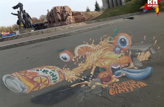 Под памятником дружбы народов появилось гигантское рекламное граффити газировки. Жуткий апельсиновый монстр тянет синий язык к оранжевой банке